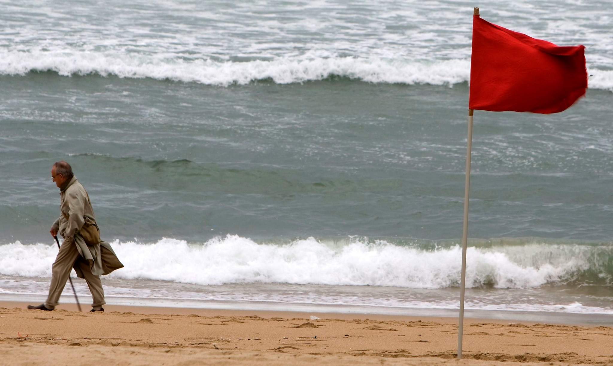 Bandera roja frente al mar. Imagen ilustrativa.