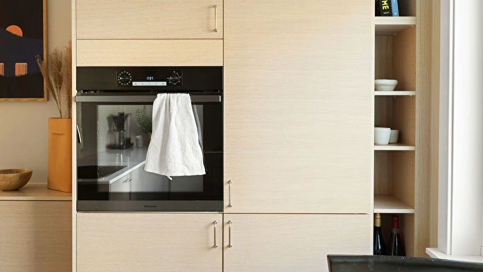 Paño blanco colgado del tirador de un horno integrado en una cocina
