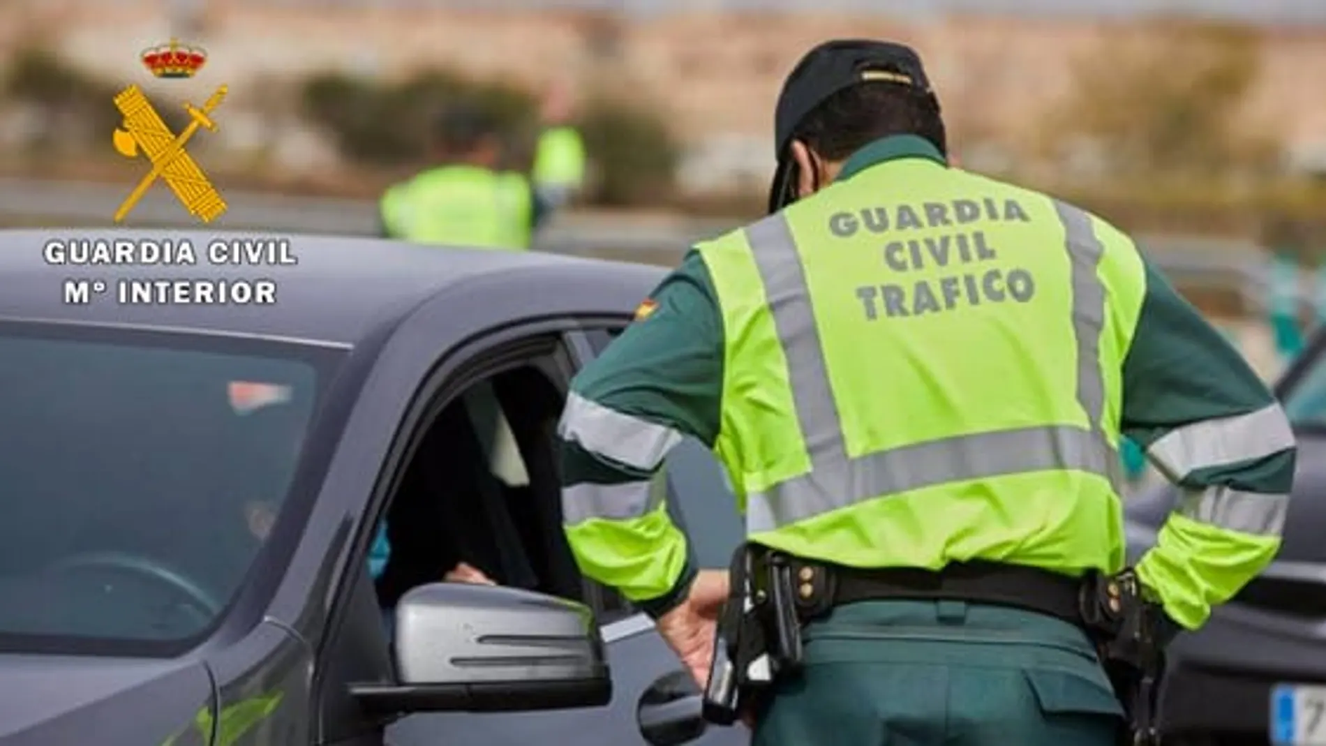 Agente de la Guardia Civil de Tráfico junto a un vehículo
